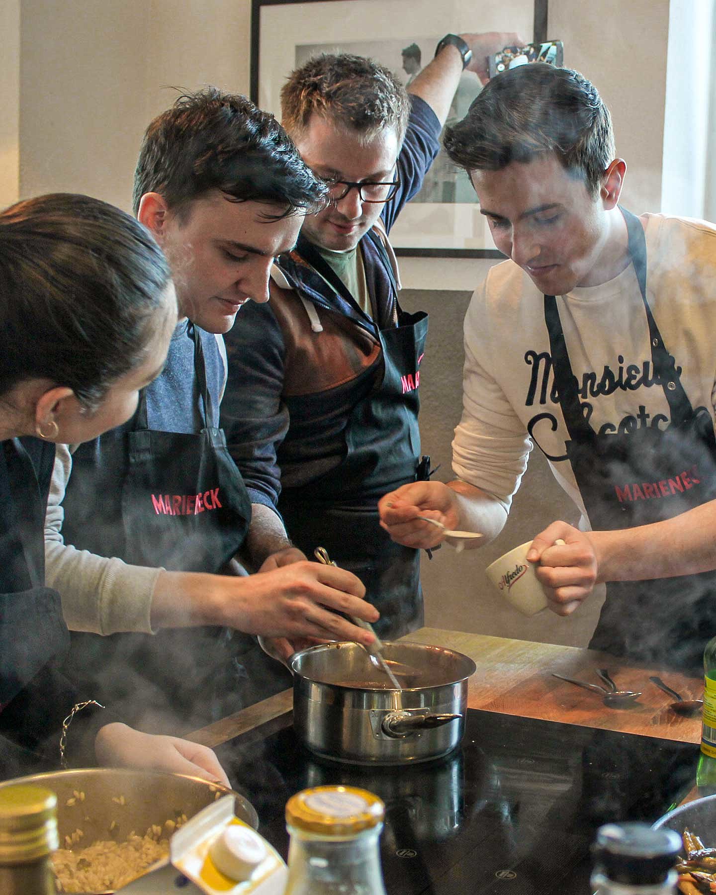 Vier Auszubildende der Deutschen Reihenhaus AG stehen vor einem Topf in der Küche