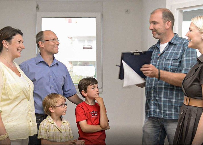 Ein Immobilienmakler übergibt das neue Deutsche Reihenhaus Haus an eine Familie